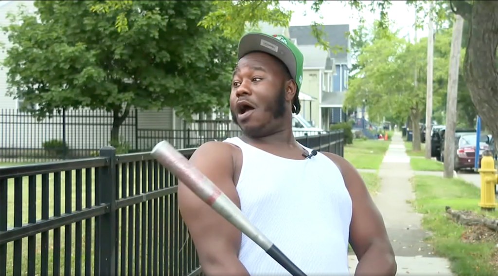 Man holding a baseball bat, describing an encounter with a large cat.