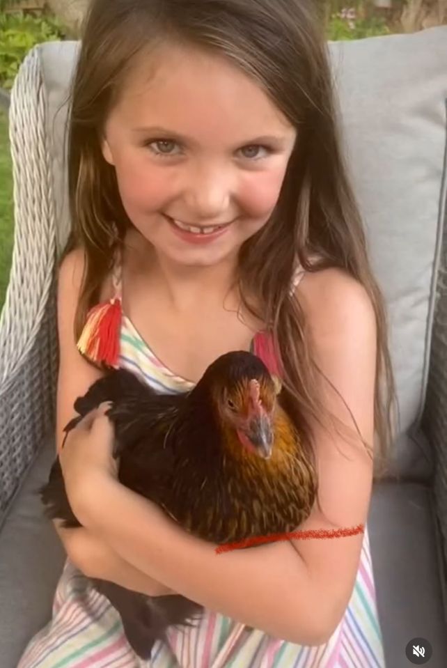 Girl holding a chicken.