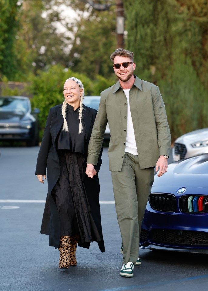 Sia and Harry Jowsey holding hands while leaving a restaurant.