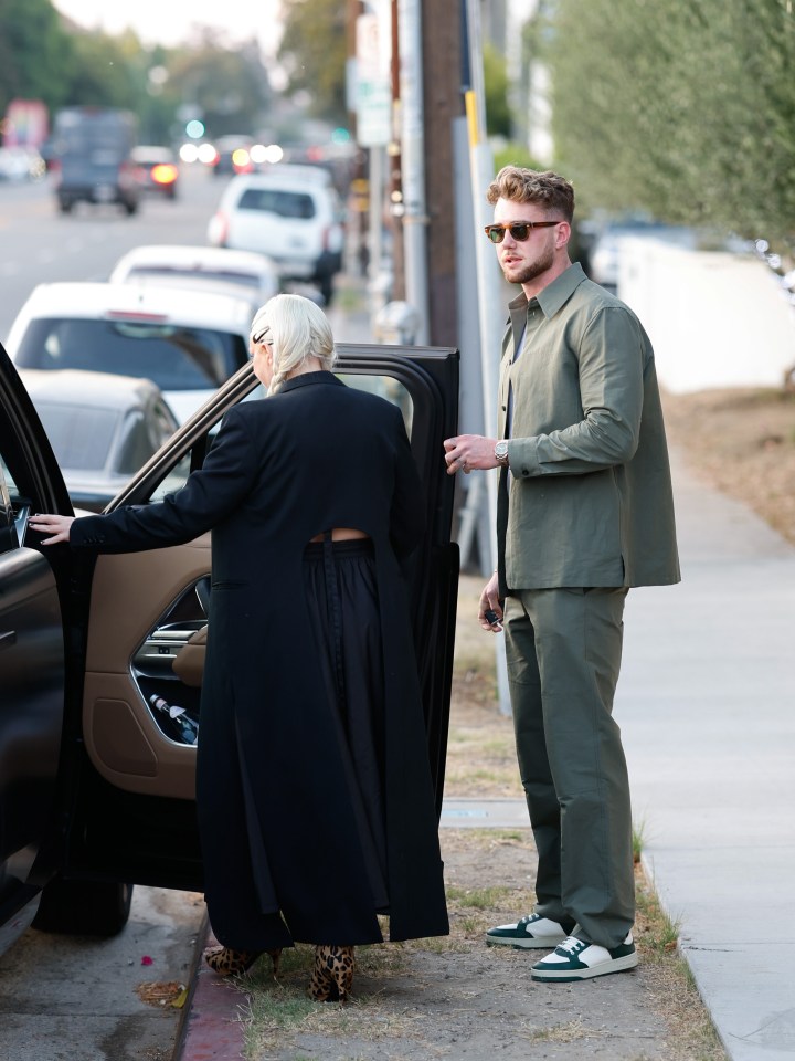 Sia and Harry Jowsey holding hands and leaving a restaurant.