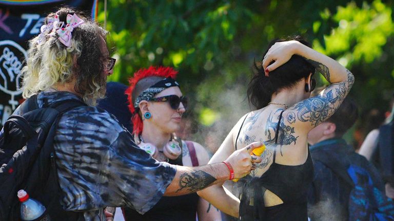 People put sun cream on during the Bristol Pride festival. Pic: PA 