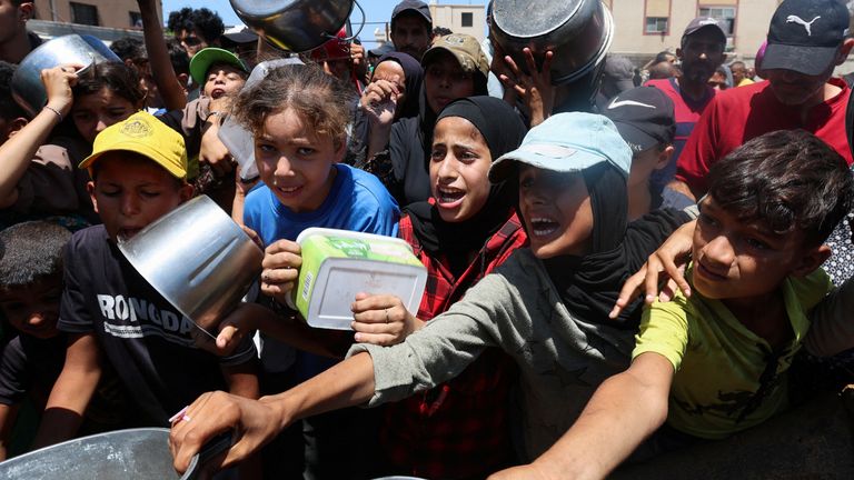 Palestinians gather at a charity kitchen in Nuseirat, central Gaza Strip. Pic: Ramadan Abed/Reuters 
