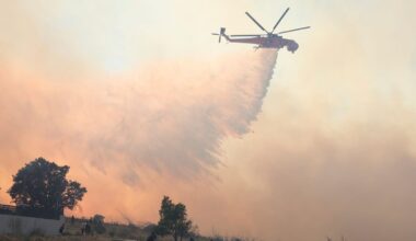 A helicopter drops water during a wildfire, in the northwestern suburb of Kryoneri, in Athens, Greece, Saturday, July 26, 2025. (AP Photo/Yorgos Karahalis)