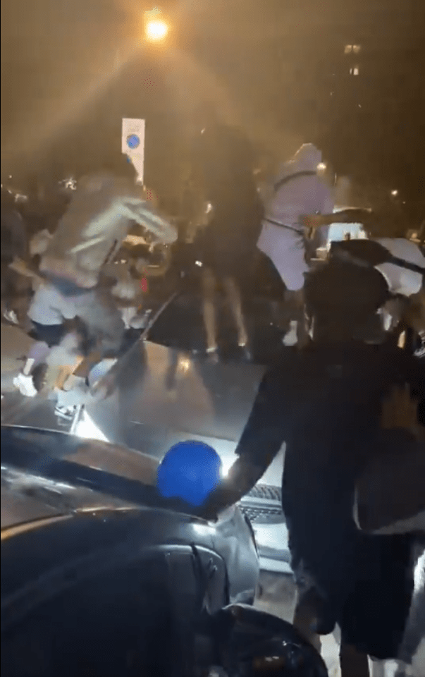 A gang attacking a car.