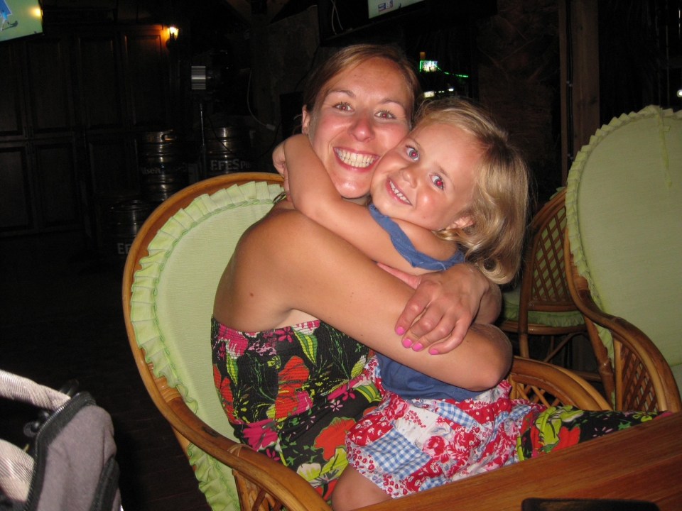A woman hugs her young daughter.