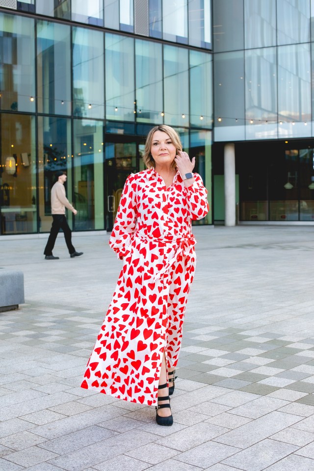 Woman in red heart dress outdoors.