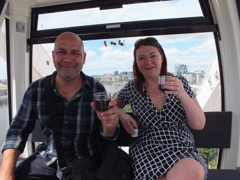 Couple enjoying wine in a Ferris wheel gondola.