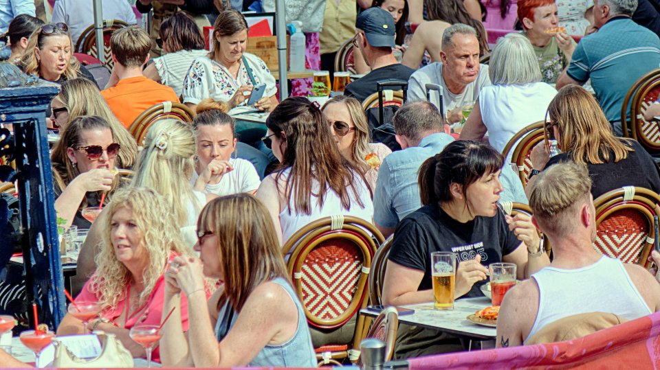 People enjoying sunny weather at an outdoor cafe.