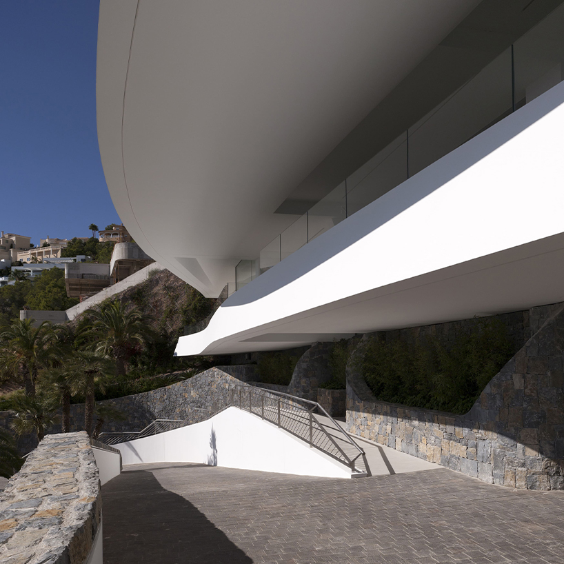 curved house's sinuous facade traces mountainous terrain in spain