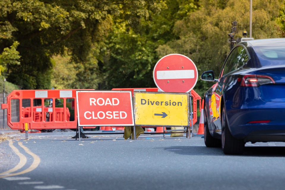 Road closed sign with detour indicated.
