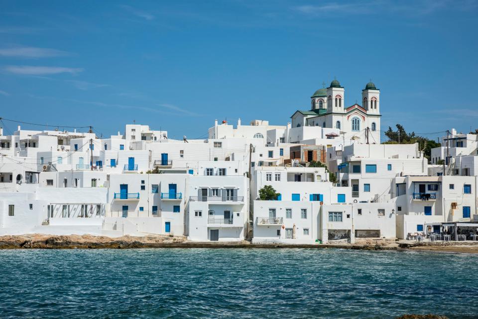 Naousa, Paros, Greece: whitewashed buildings and a church by the sea.