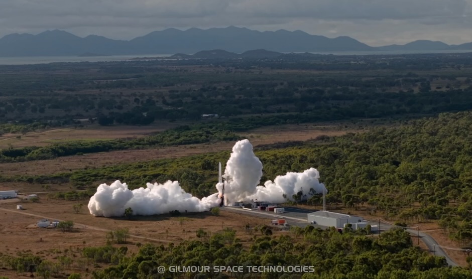 a white rocket launches into a cloudy sky, with mountains in the background