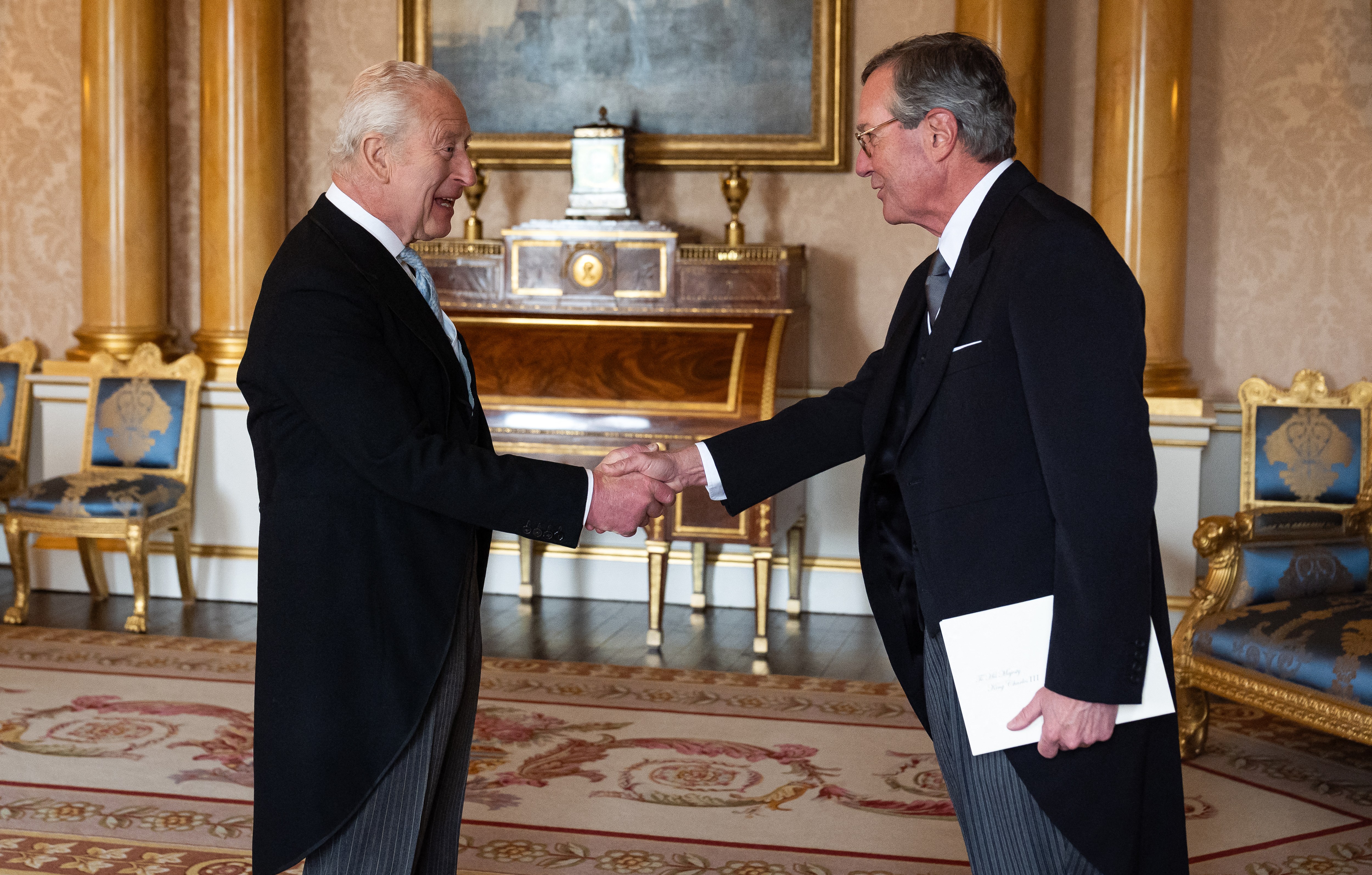 King Charles III shaking hands with the US Ambassador at Buckingham Palace.