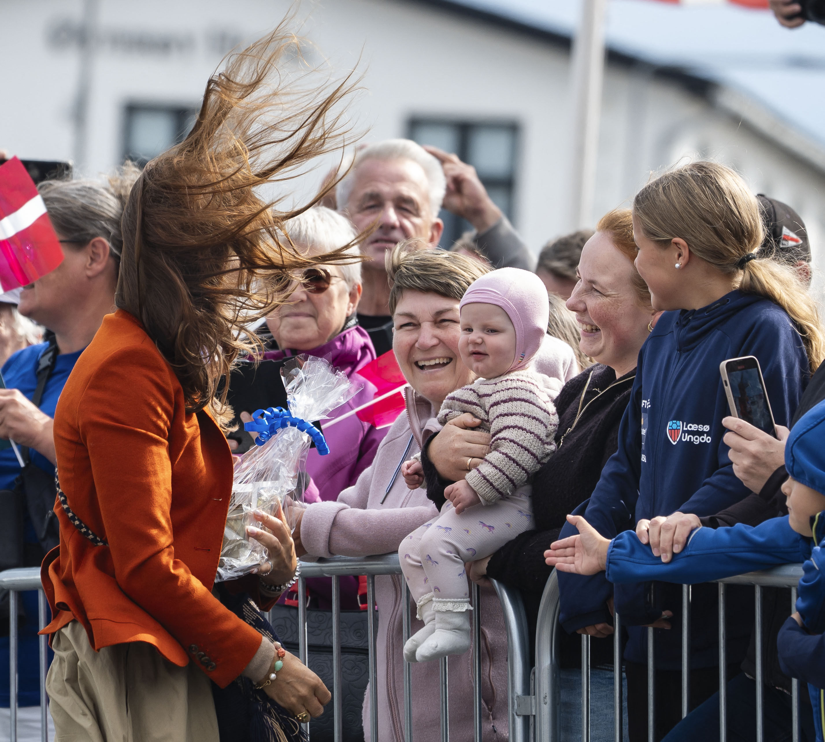 Queen Mary receiving gifts during a windy visit.