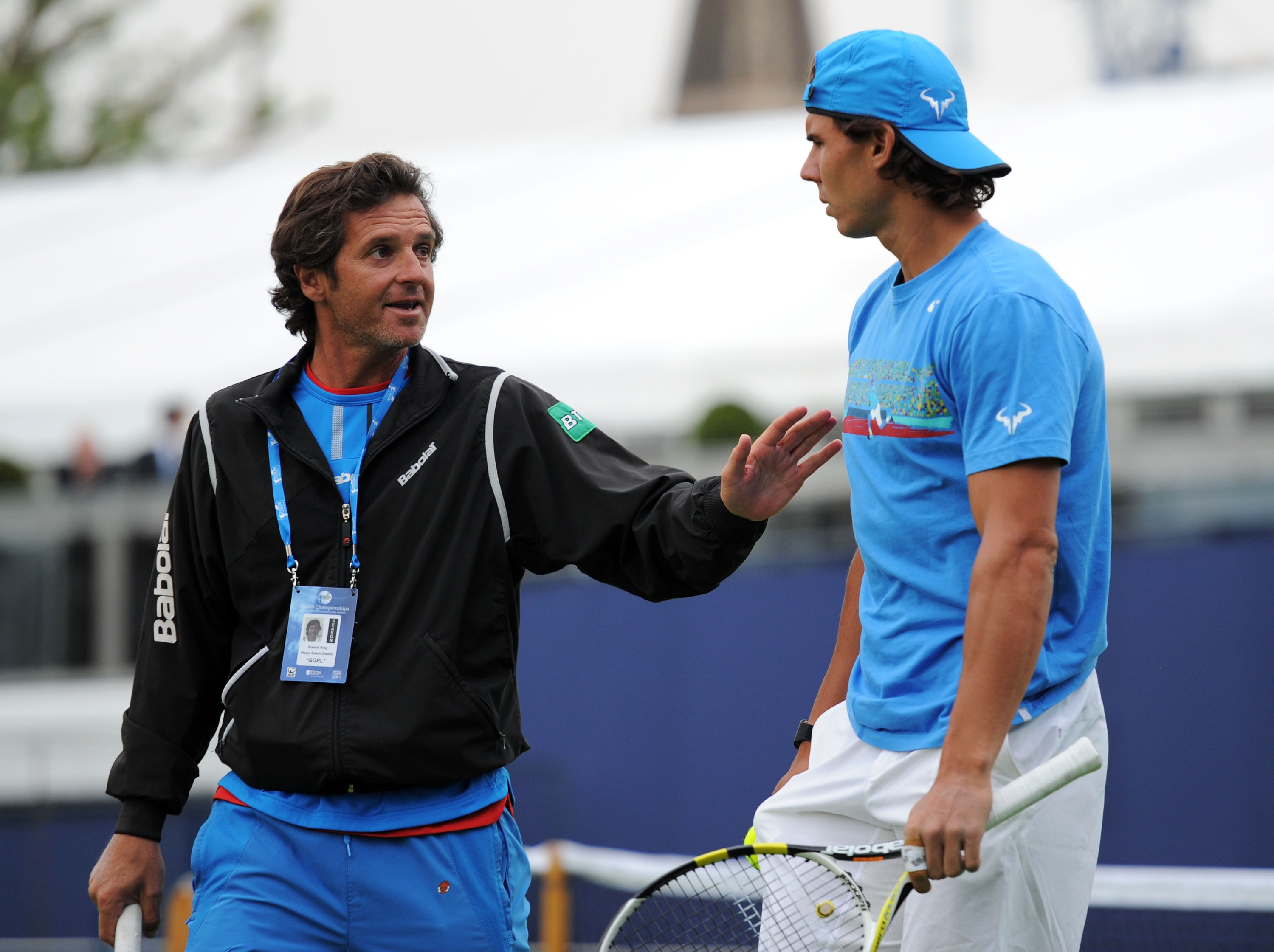Rafael Nadal and his coach talking on a tennis court.