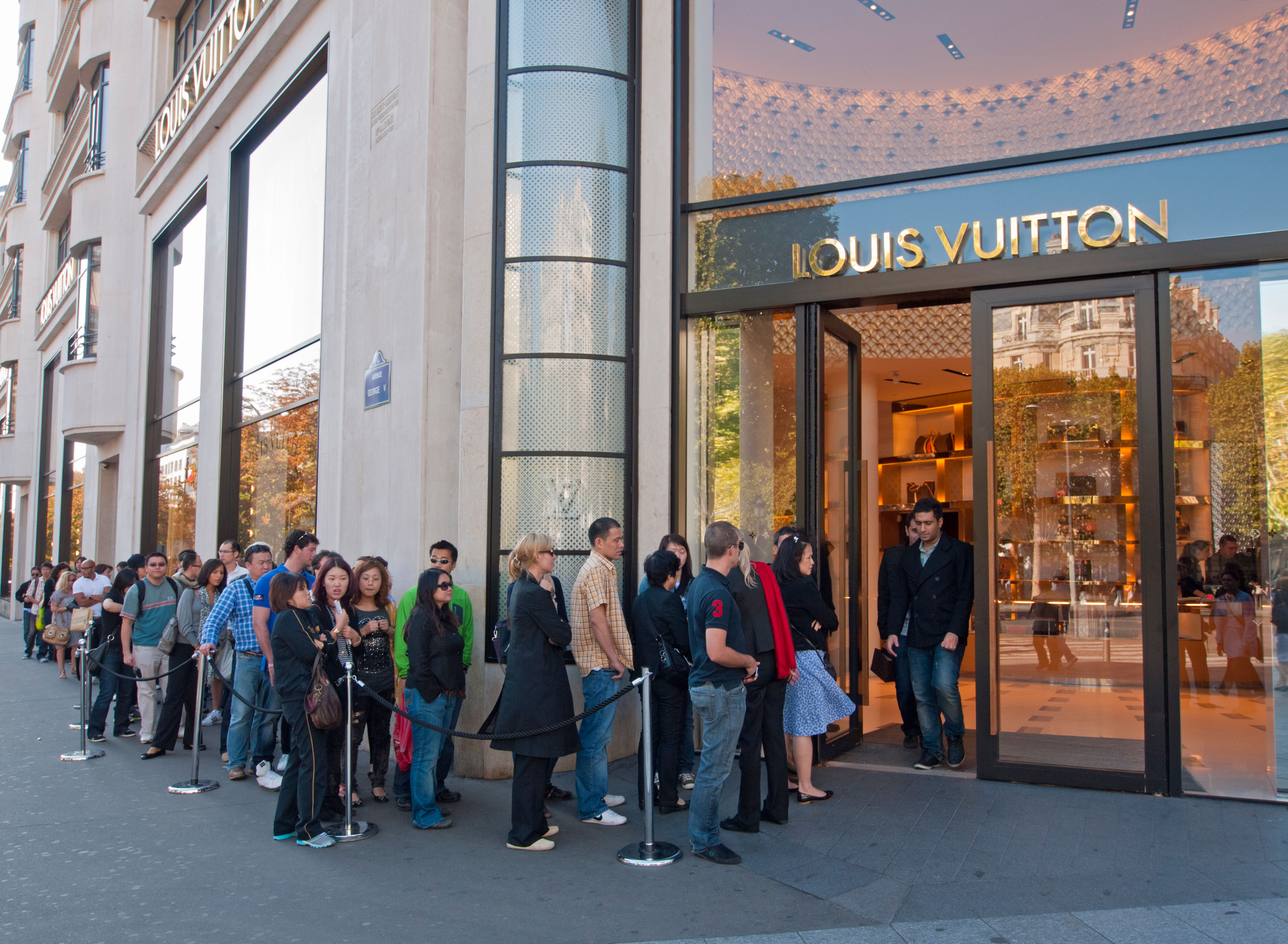 Queue of shoppers outside a Louis Vuitton store.