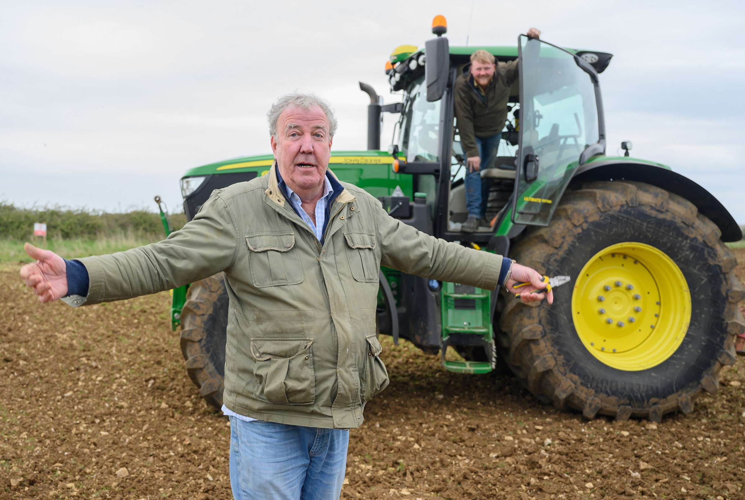 Jeremy Clarkson and Kaleb Cooper on a farm with a tractor.
