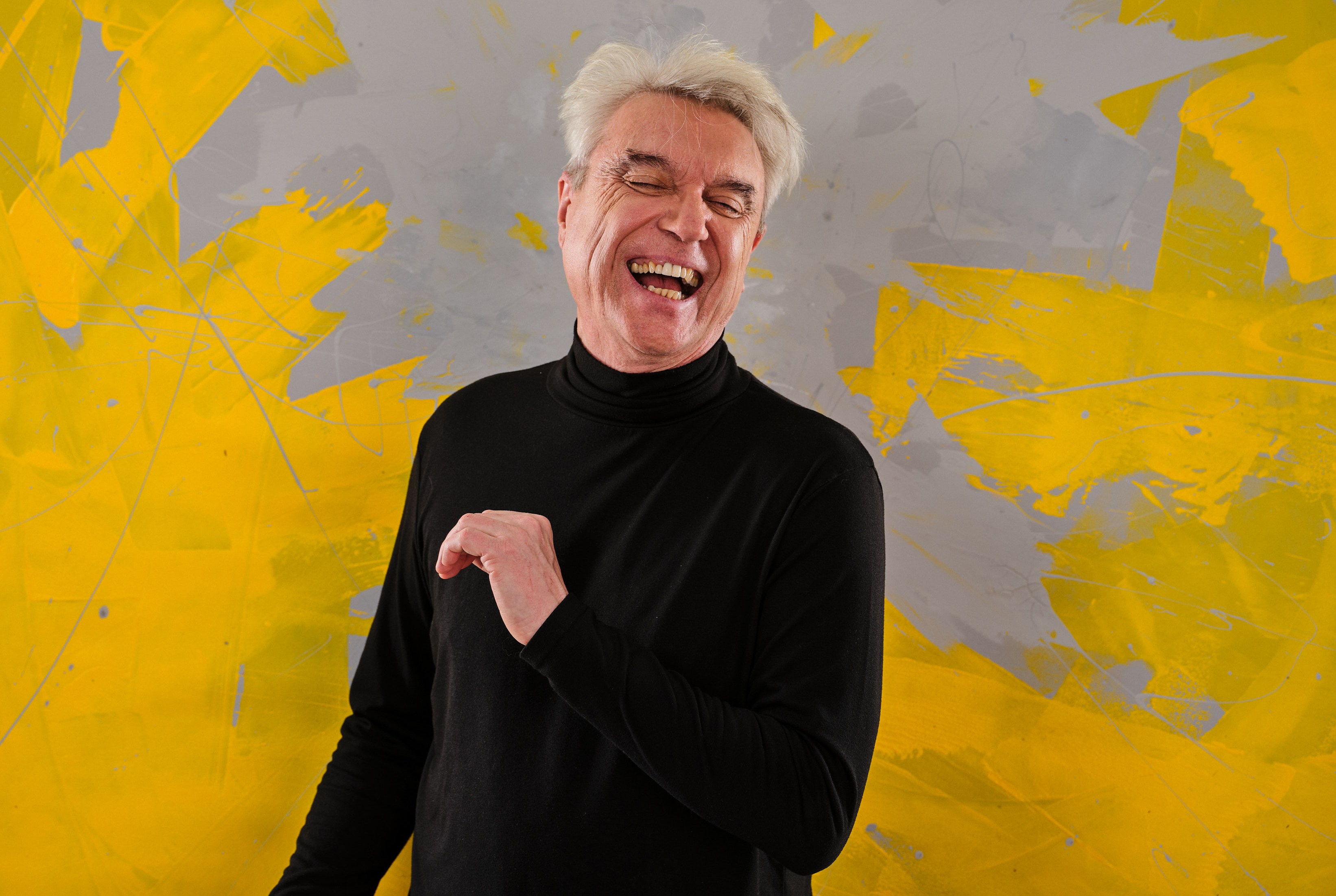 Portrait of David Byrne laughing.