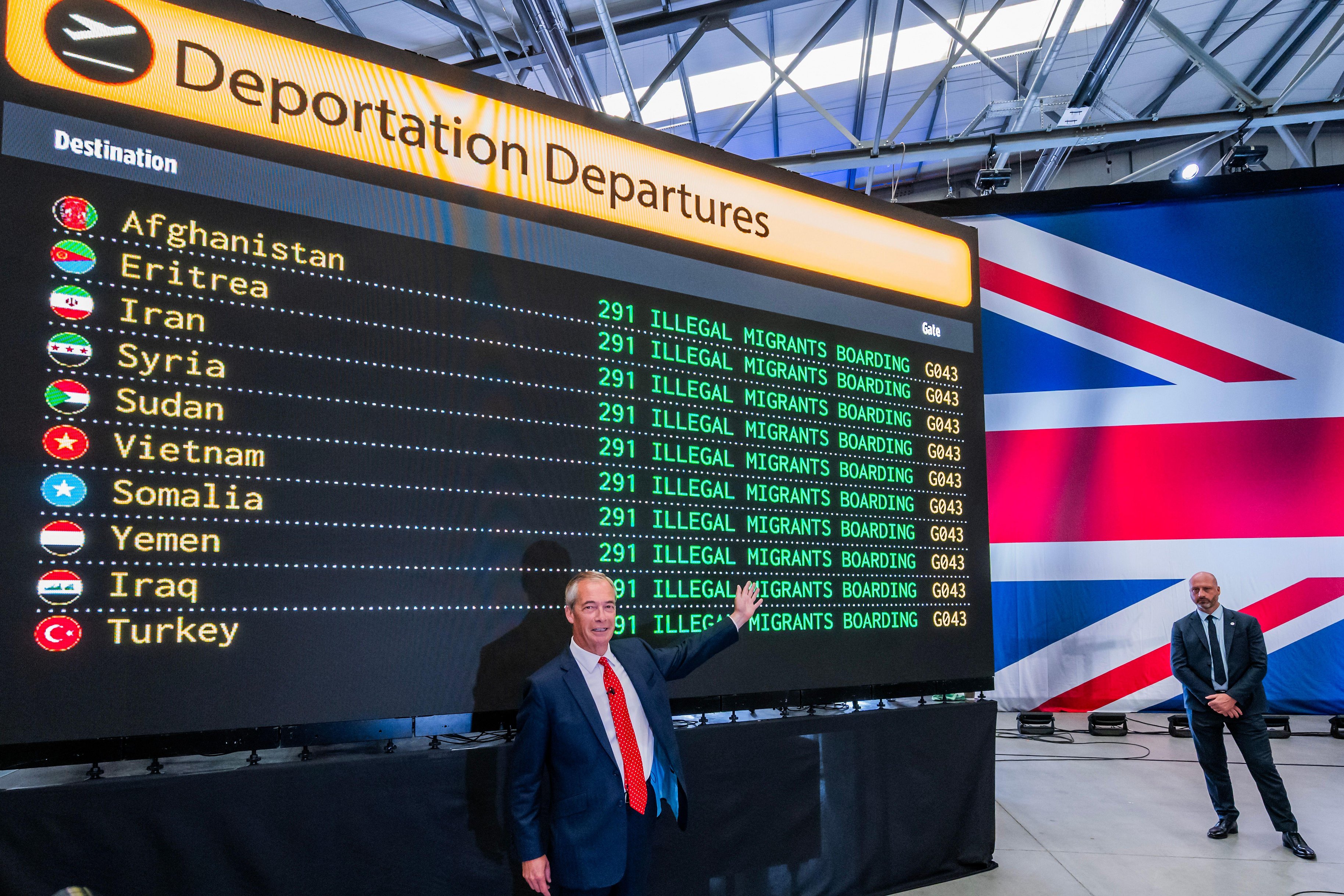 Nigel Farage at a press conference announcing deportation plans, with a departure board listing countries and numbers of migrants.