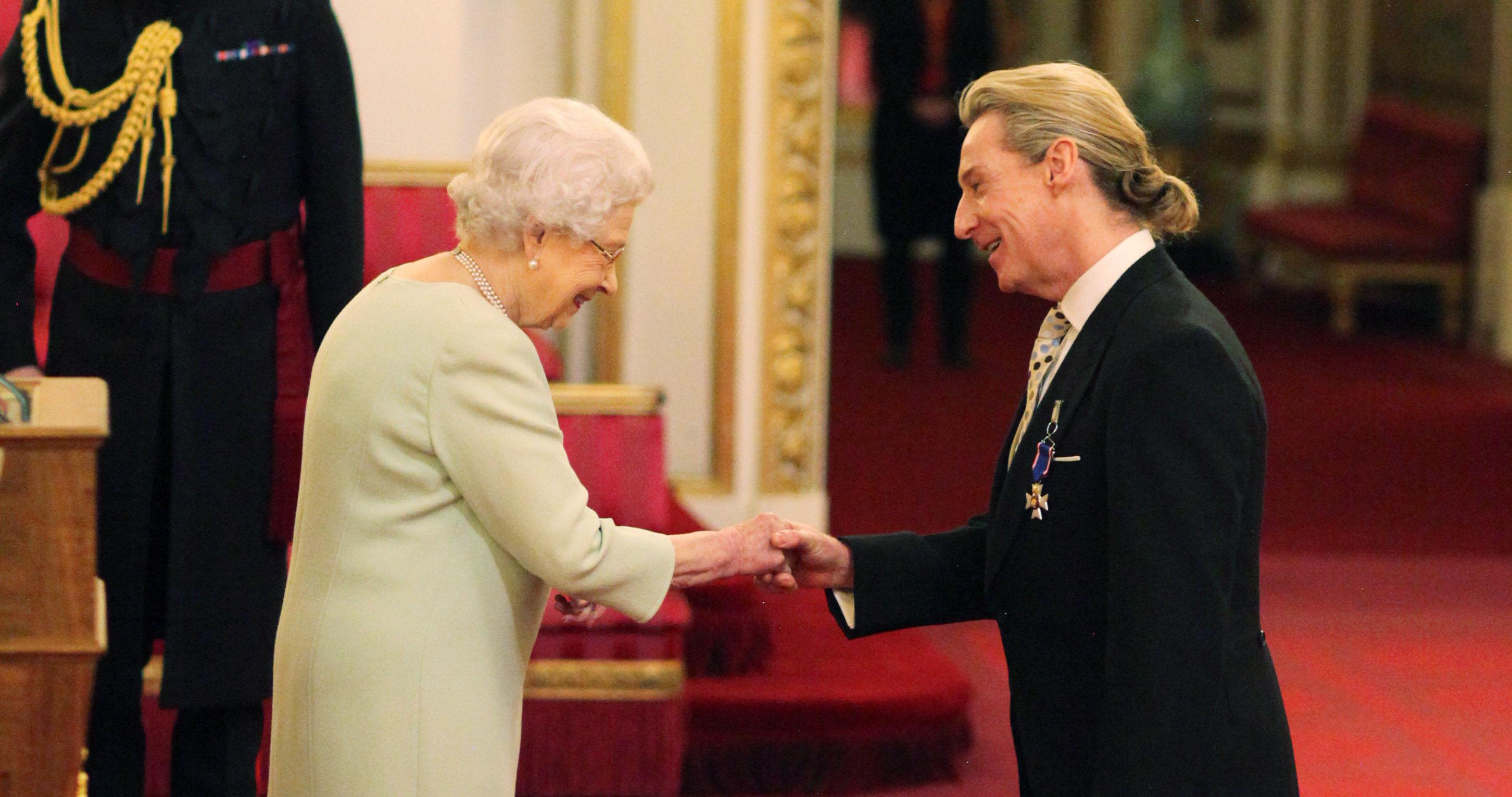Queen Elizabeth II bestowing an award on John Carmichael at Buckingham Palace.