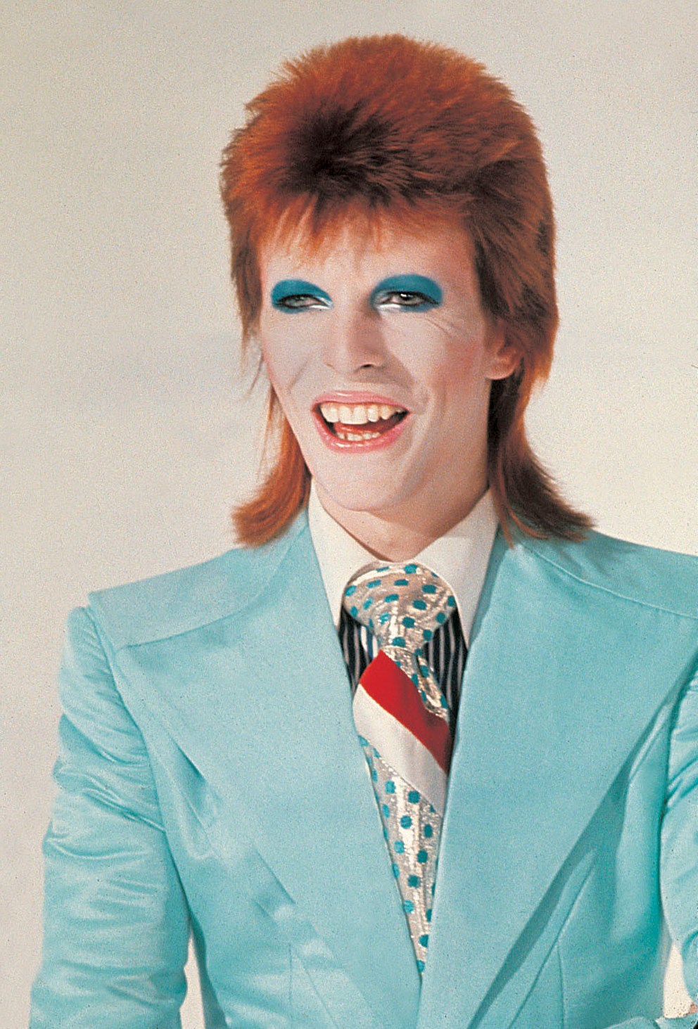 Photo of David Bowie in a light blue suit.