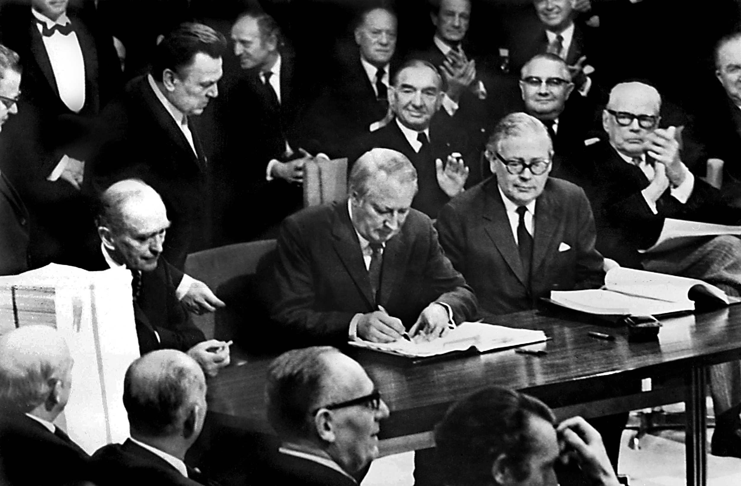 Black and white photo of Edward Heath signing the UK's accession to the EEC.