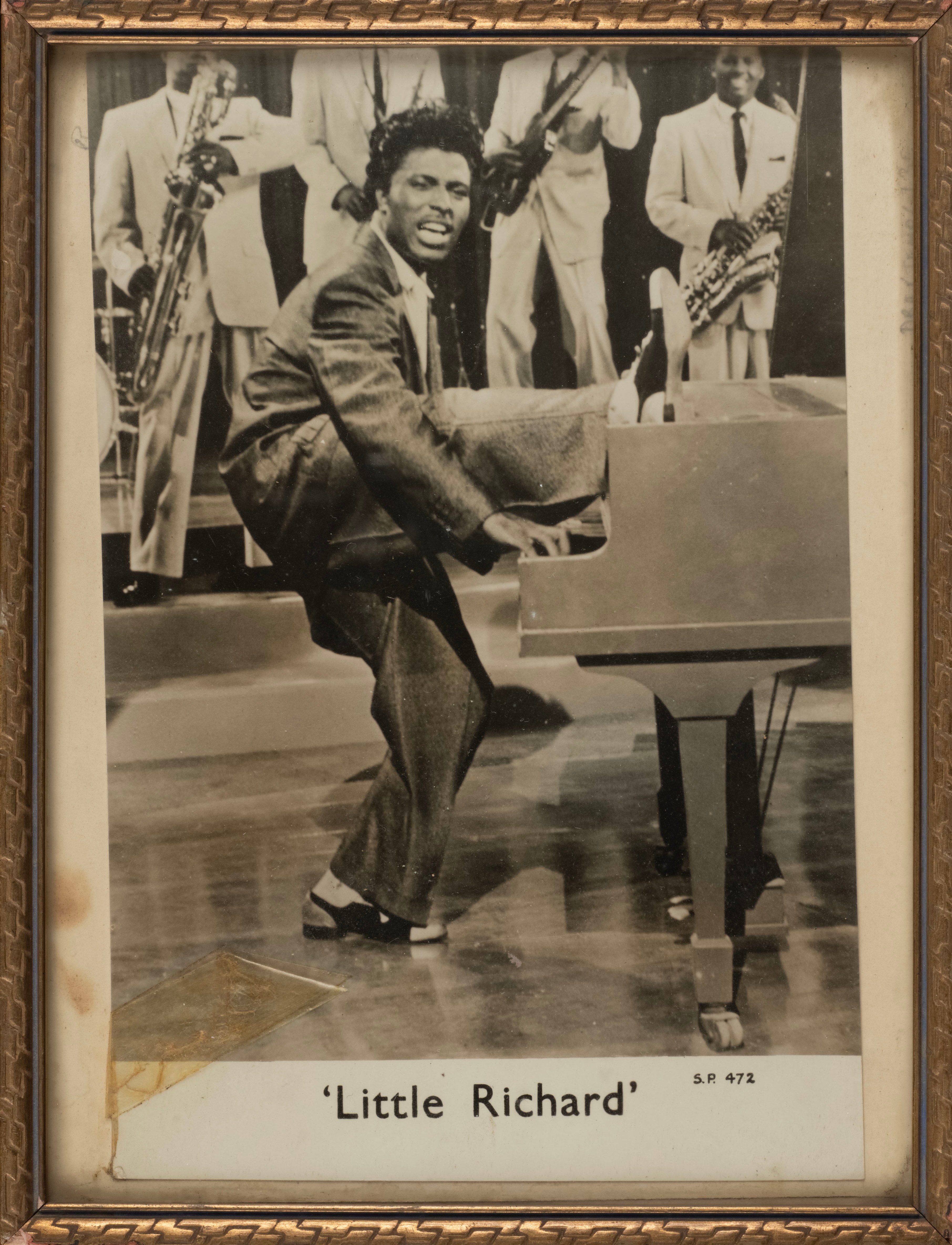 Framed black and white photo of Little Richard playing piano.