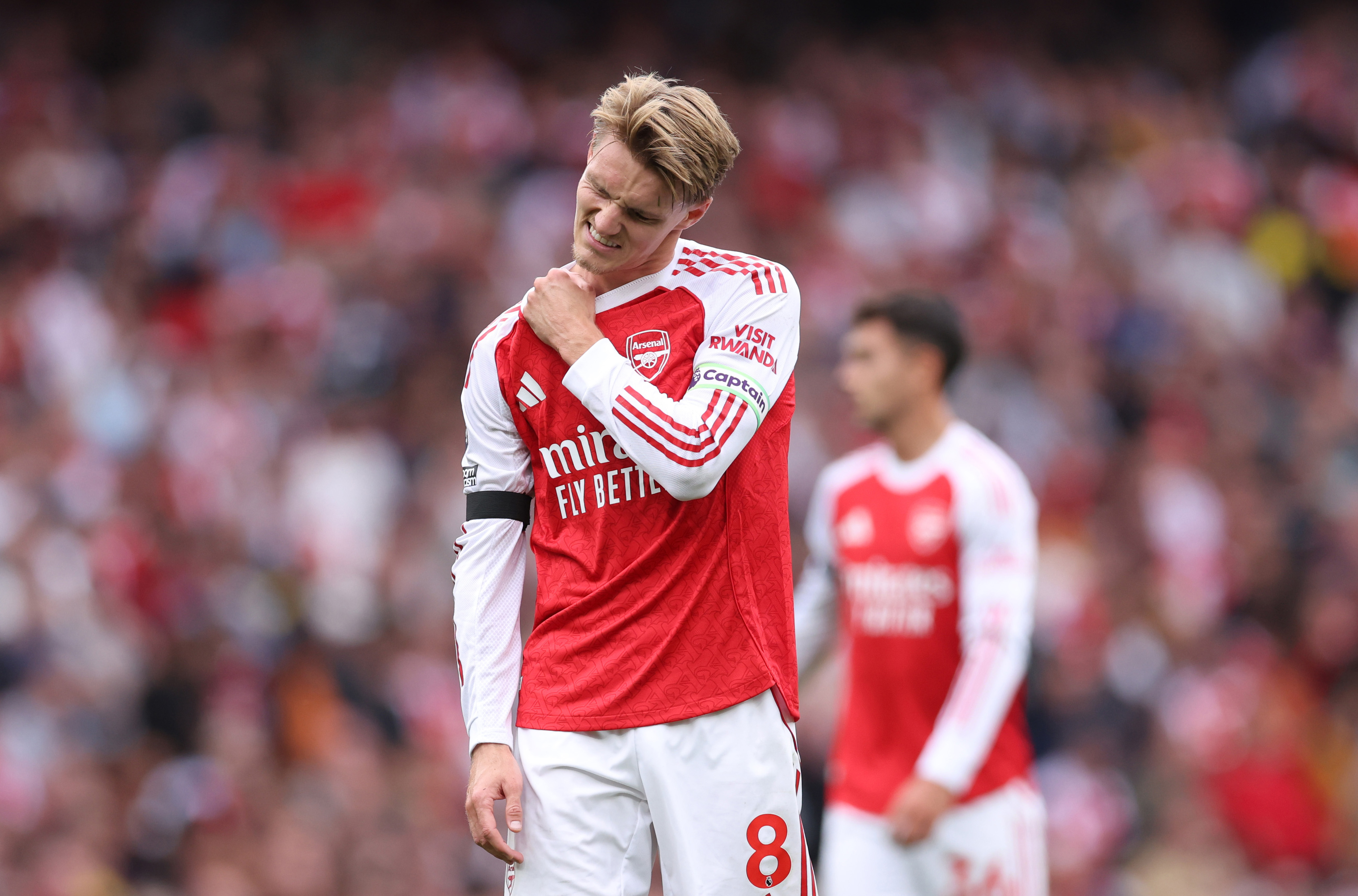 Martin Odegaard of Arsenal holding his shoulder after a challenge.