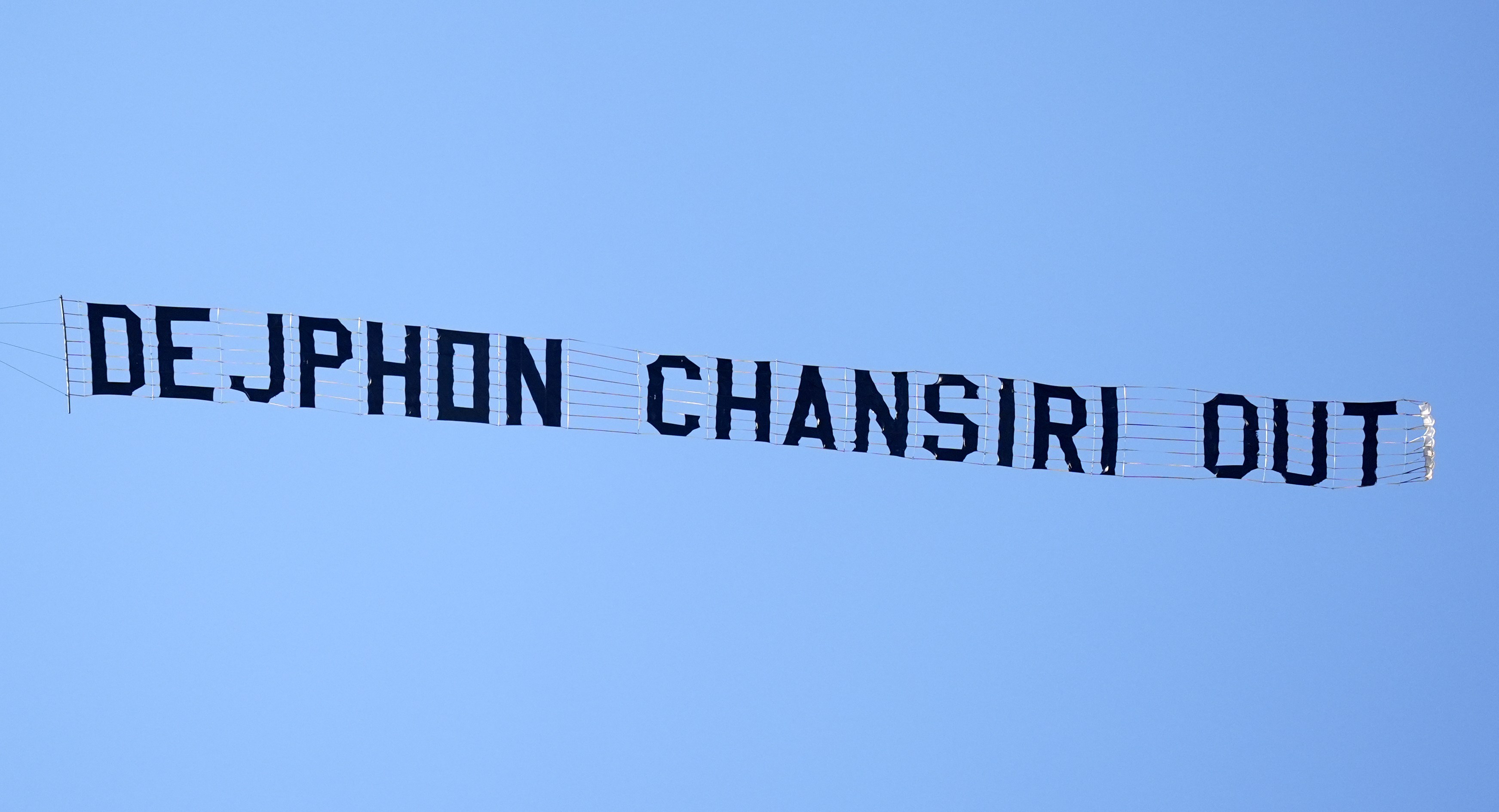 Plane banner reading "DEJPHON CHANSIRI OUT".