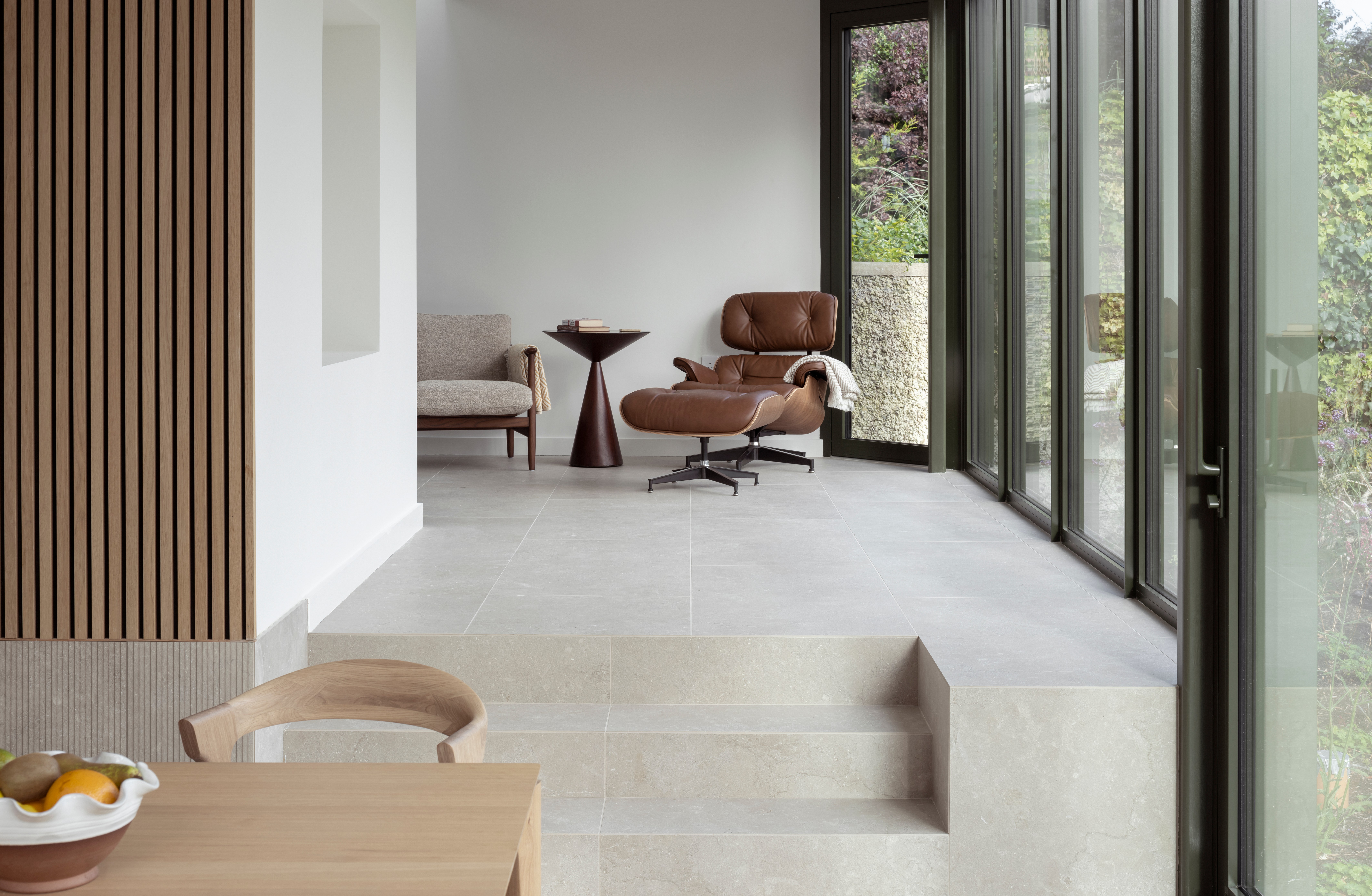 Modern living room with leather armchair and large windows.