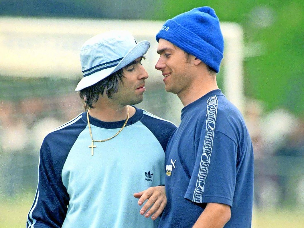 Liam Gallagher and Damon Albarn at a football match.