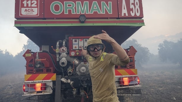 A Firefighter and truck with smoke in background in Turkey