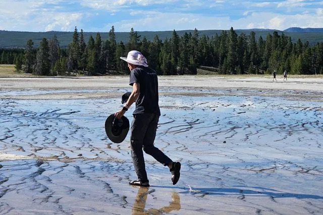yellow stone national park invasion of the idiots/Facebook A man walks across off-limits bacterial mats in Yellowstone National Park