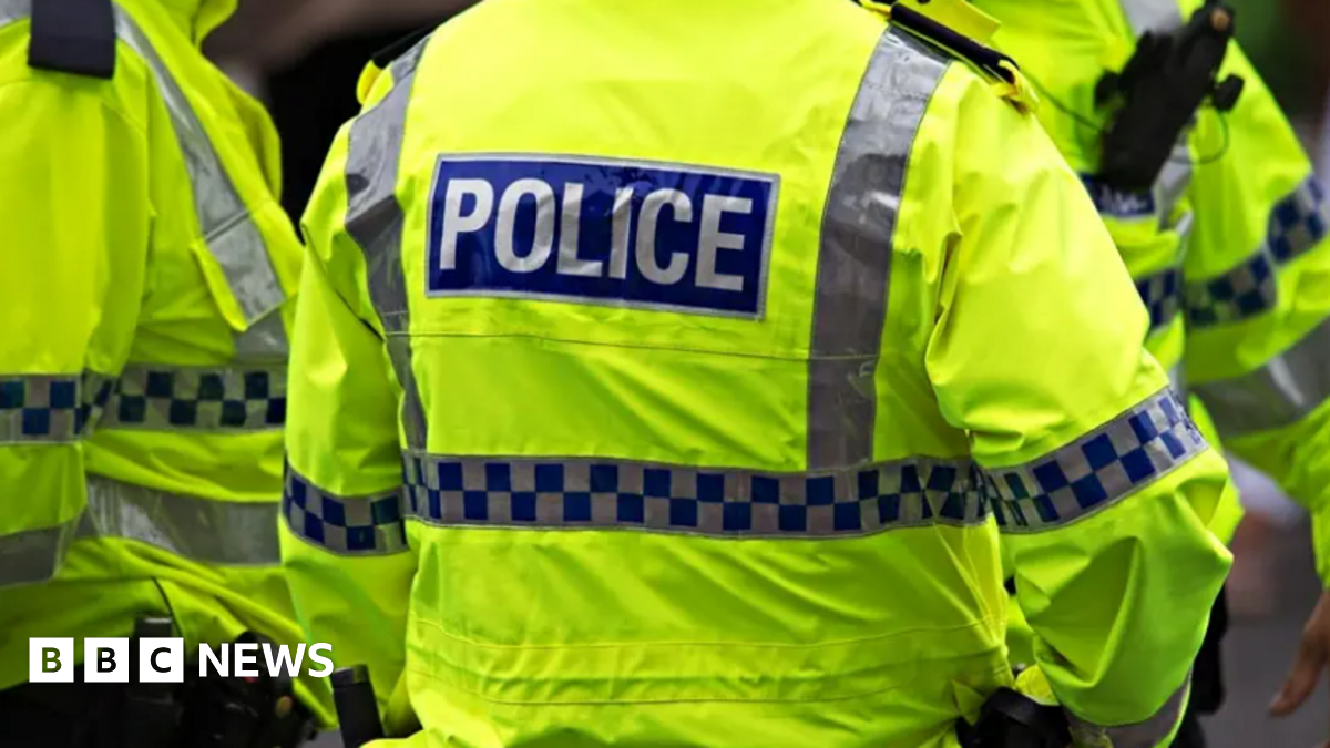 Image shows the back of a police officer's florescent yellow-green jacket. It has the word POLICE written in white capital letters on a blue background.