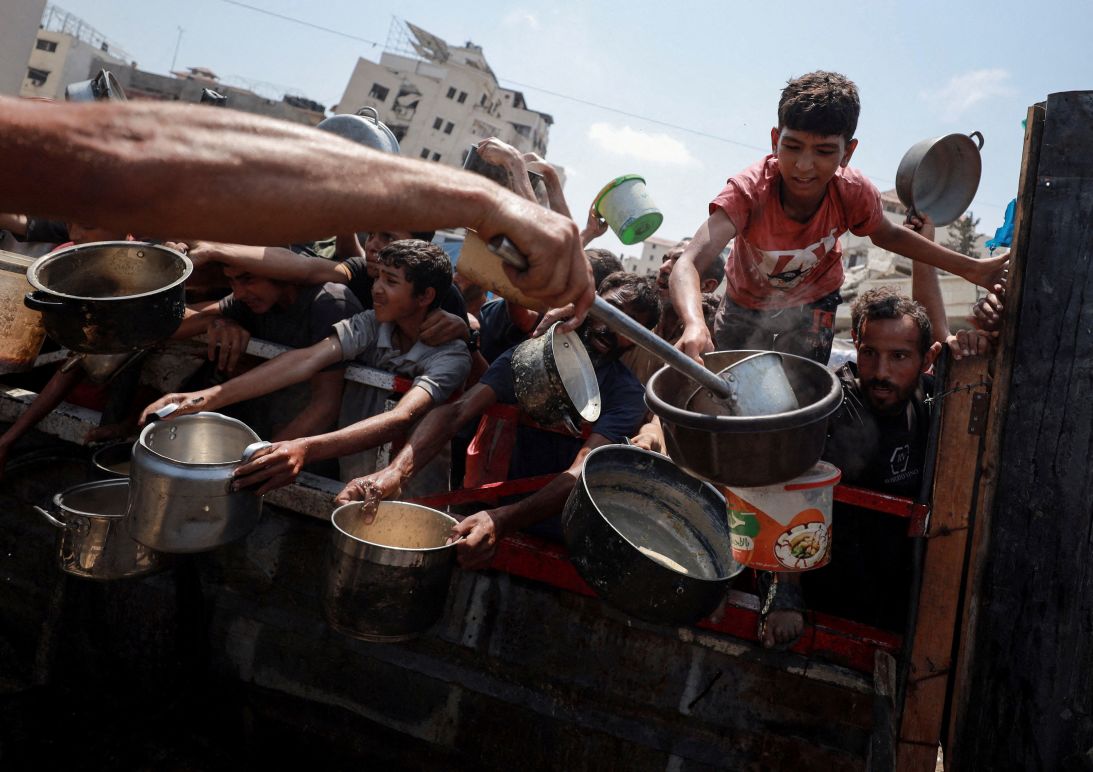 Palestinians gather to receive food from a charity kitchen amid a hunger crisis in Gaza City on Monday.
