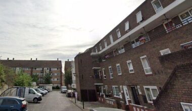 Google street view image of Russia Lane which has several blocks of flats built alongside a car park that has vans and cars parked in it