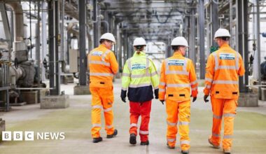 Four Vivergo workers wearing hi-viz outfits walking in front of machinery at the bioethanol plant in Hull