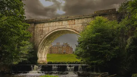 Phil Dawson A view of the River North Esk looking towards Dalkeith Palace with Montagu Bridge in the foreground making an arch with the palace filling the space. 