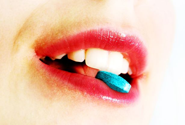 Close up of lips with a blue pill