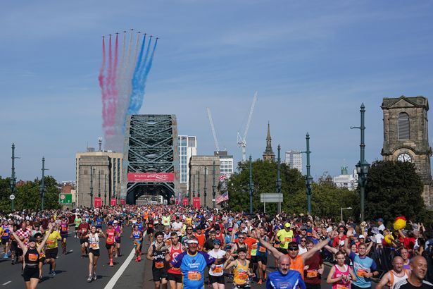 Great North Run runners heading over the Tyne Bridge with the Red Arrows in the background