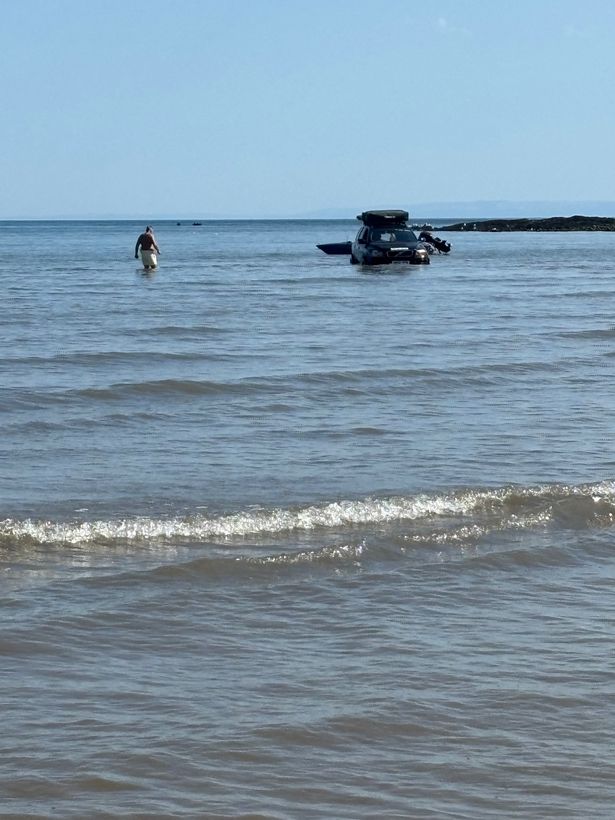 Car in the water at Oxwich Bay