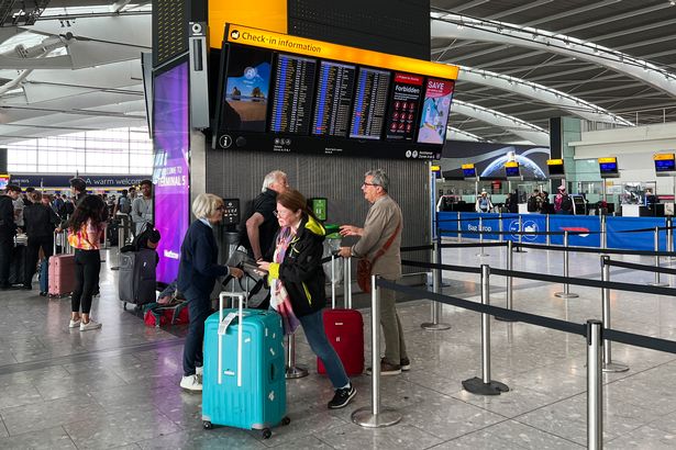 Passengers look at the departures board at Heathrow Airport, in London, Monday, Aug. 28, 2023.