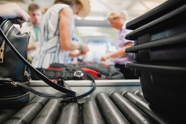 Luggage being inspected by security at the airport.