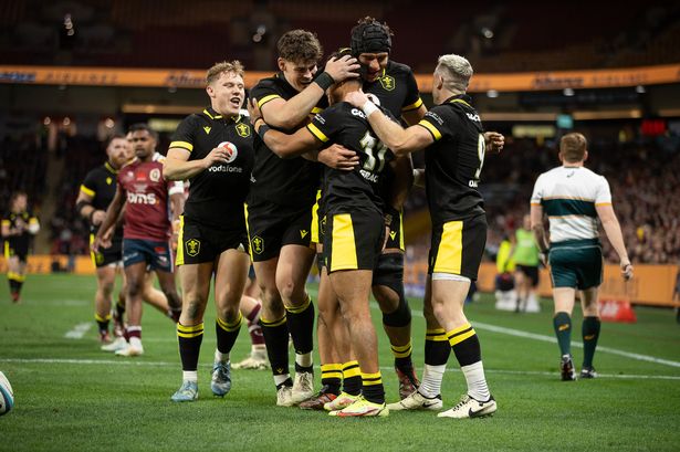 Grace is mobbed after scoring a try on his Wales debut