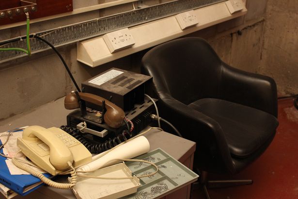 A seat and desk with old telephones once situated in Oldham's very own nuclear bunker. 