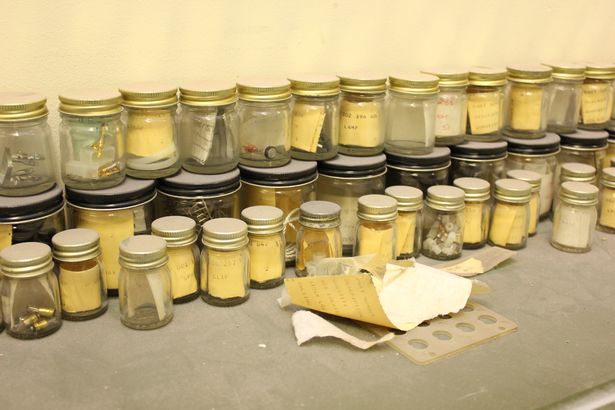 Jars full of spare fuses and electrical parts on a work bench. 