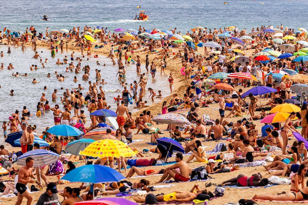 Crowds of tourist on Barceloneta beach, Barcelona, Spain