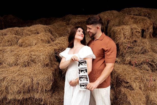 Isabel Hodgins and Adam whitehead with baby scan in front of hay bales