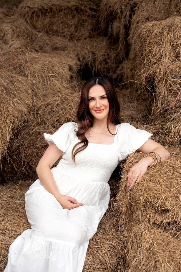 isabel hodgins in white dress on a hay bale