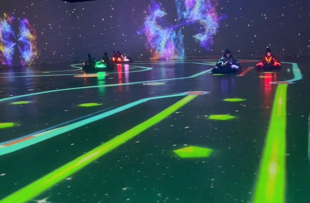 Tracks and surrounding landscapes are projected onto the floor and walls